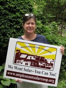Anya Schoolman displays a Mt. Pleasant Solar Cooperative sign in 2007.
