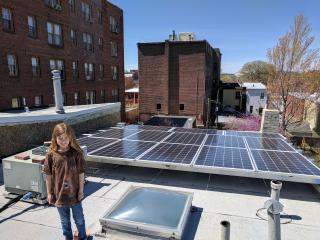A young co-op member with her family's rooftop PV system