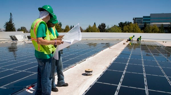 Installers work on a rooftop solar system in Oklahoma