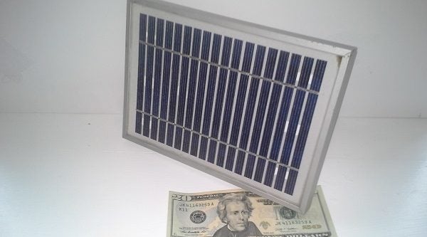 A solar panel over a twenty dollar bill