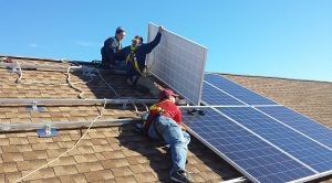 Installers mounting solar panels on a multi-array system
