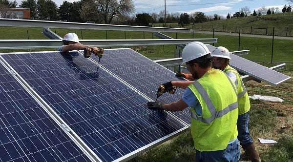 Installers work on a community solar project in Virginia.