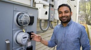 A solar homeowner in Millvale, Pennsylvania shows off his energy meter and his solar inverter.